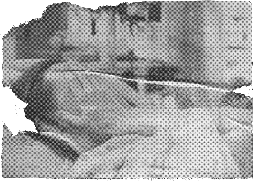 A woman in a hospital bed covering her face with her hands