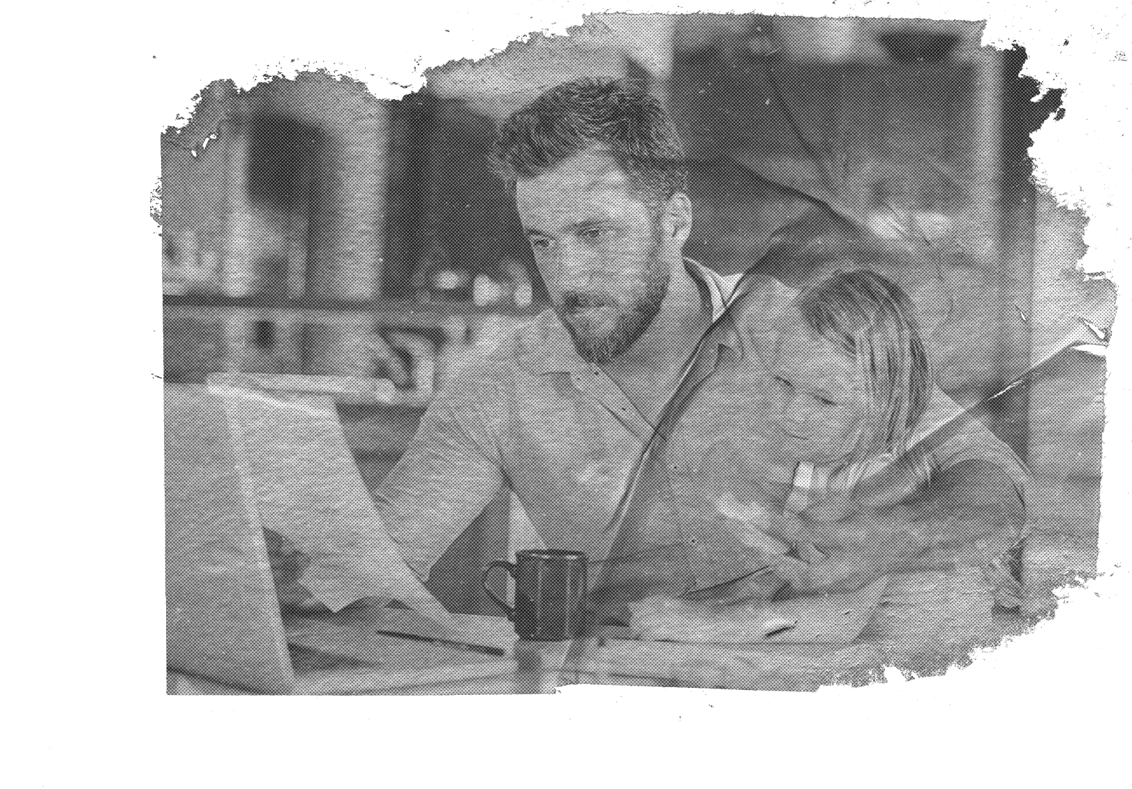 A man holding his child on his lap, reviewing paperwork with his laptop open
