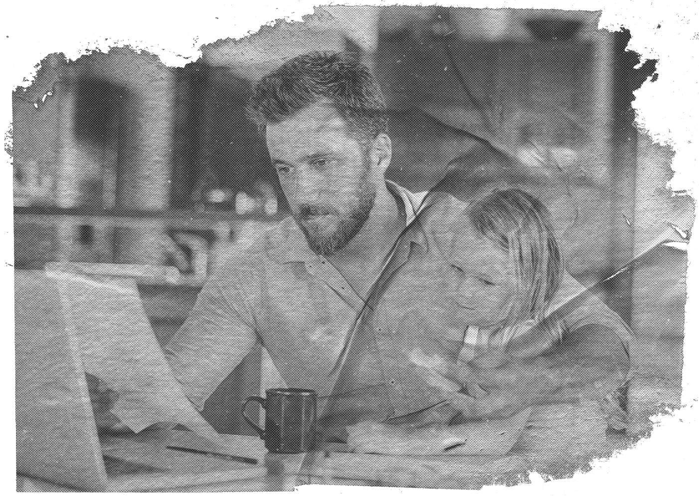 A man holding his child on his lap, reviewing paperwork with his laptop open